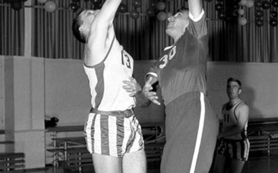 Bob Cousy, right, takes a shot as Fuerstenfeldbruck player (and future University of North Carolina coaching legend) Dean Smith defends during the 1955 USAFE clinic.