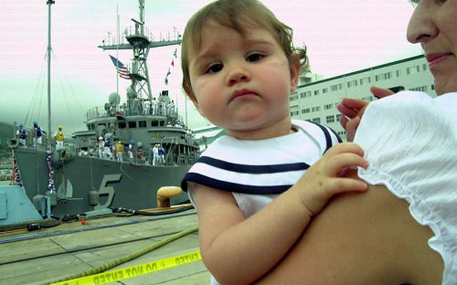 Sofia Summerhill's dad was almost home as the USS Guardian tied up at Sasebo Naval Base's India Pier. Her mother, Yvonne, is holding the 11-month-old. Sofia had no interest in wearing her sailor hat.