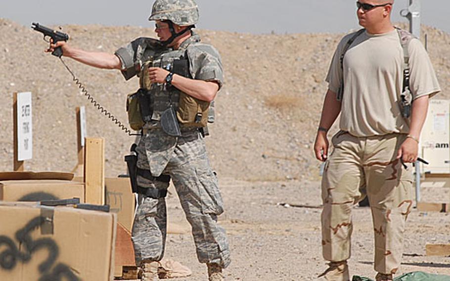 Shooting tournament official and U.S. Air Force Staff Sgt. Kerry Koepp, 28, of Chicago observes an Air Force airman as he fires one-handed at a target.