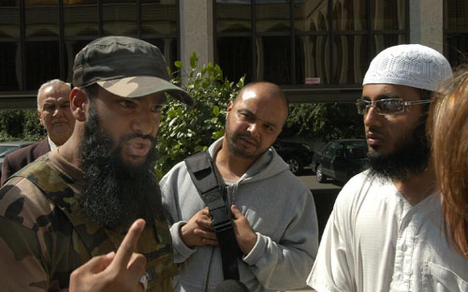 Abu Farooq, 22, left, speaks passionately about his perceived oppression in Britain outside London's Islamic Cultural Center. Farooq, and his comrade in white, Abu Samaha, 25, were two of the roughly two dozen young Muslim men who were excluded from the conference for what they say are their radical views.