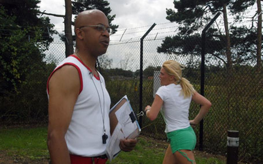 Territorial Army Lance Cpl. Stephen Grant cheers on participants in the 1.8-mile foot race that kicked off the sports day challenge. Grant works as a Ministry of Defense civilian employee and serves with the 45th Royal Signal Regiment out of Colchester, Essex.