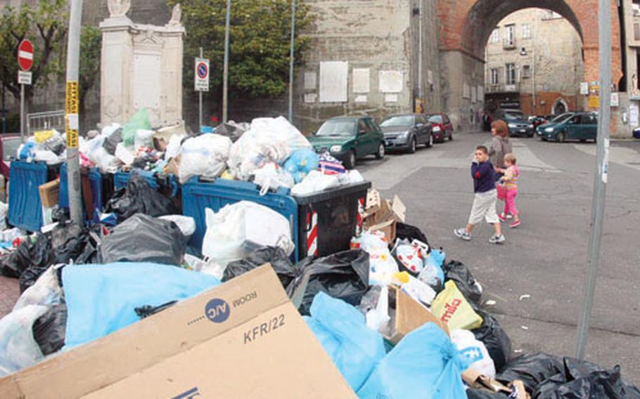 A boy plugs his nose Tuesday as he walks by a pile of garbage that has sat uncollected for weeks in the quaint seaside town of Pozzuoli, a suburb of Naples, Italy. The city is again besieged by a trash crisis as landfills are filled to the brim and collectors have no place to dump the trash.