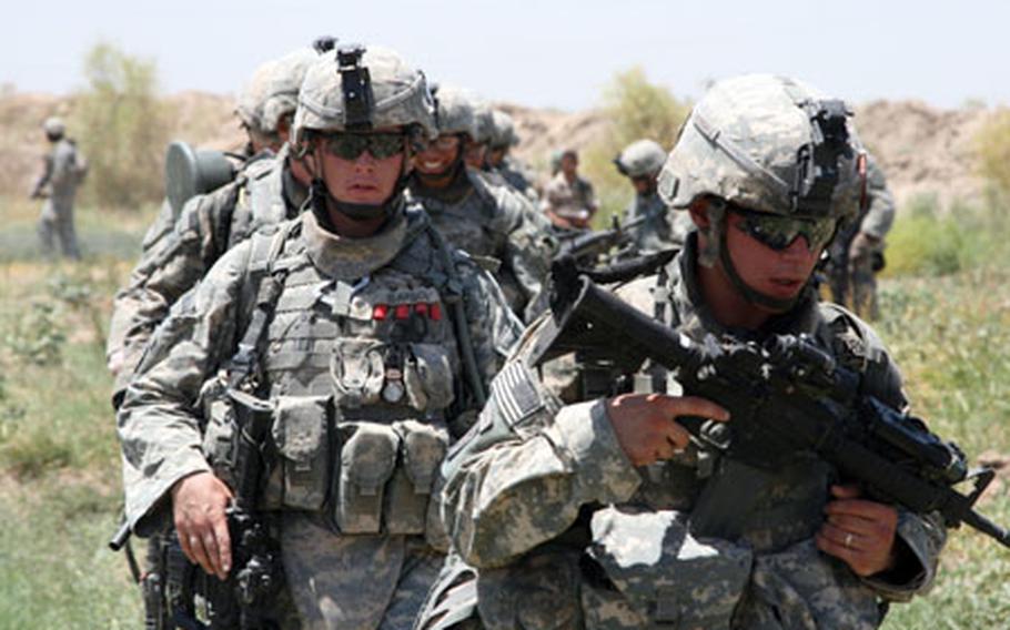 Pfc. Juan Rodriguez, 21, of San Juan, Puerto Rico, and Spc. Zachary Isakson, 22, of Madison, S.D., move across a field during a sweep operation south of Mahmudiyah last Thursday. Both troops are with Battery B, 2nd Battalion, 15th Field Artillery Regiment.