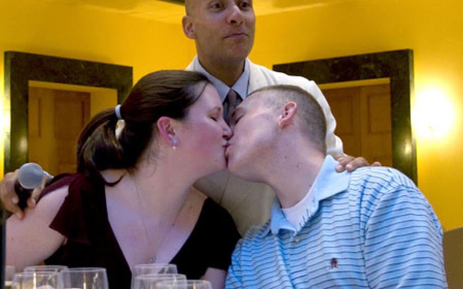 Sgt. 1st Class Antonio Giuliano of the U.S. Army Chorus, "Pershing's Own," encourages Sgt. Robert Evans and his wife, Karen, to kiss at Friday's dinner for wounded servicemembers at the Italian Embassy in Washington. The Evanses are about to celebrate their first wedding anniversary.