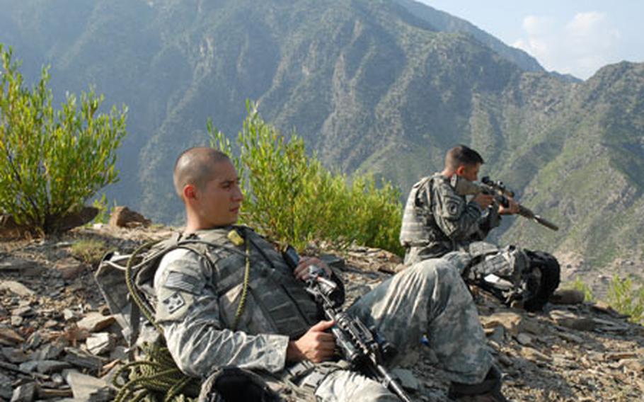 As Sgt. Scott Lombardi (right), 31, of Salt Lake City, scans a nearby valley with his rifle scope, Sgt. Raul Rodriguez, 24, of Laredo, Texas, takes a break in Nuristan Province, Afghanistan, on Saturday.
See for more photos.
