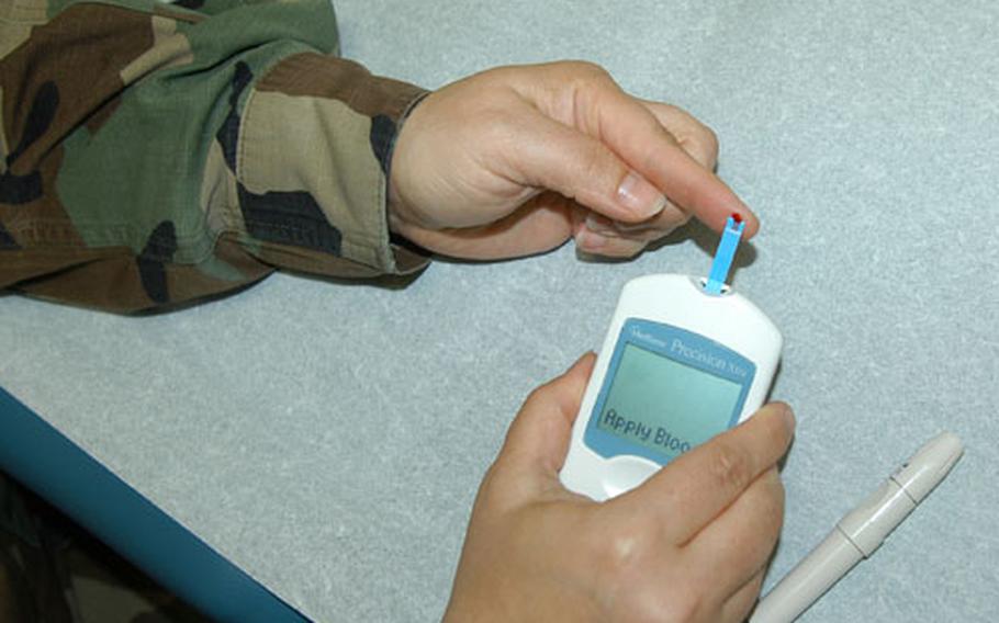 Capt. Deborah Hoffman, a pediatric nurse and certified diabetes educator with the 35th Medical Group at Misawa Air Base, Japan, pricks her finger to demonstrate one way diabetics can test their blood sugar.