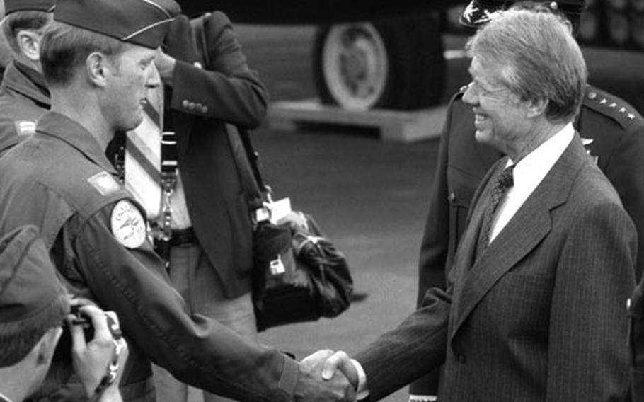 Ptresident Carter shakes hands with Maj. David H. Love, F-111 instructor pilot and aircraft commander, at Rhein-Main Air Base. Love said earlier that he was "very proud" to get his plane "polished up" as part of a static display of aircraft for the president.