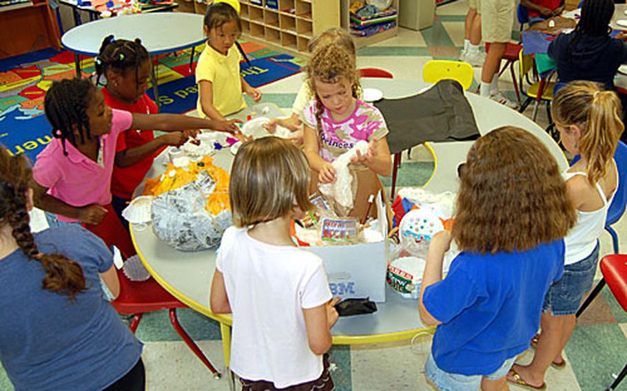 Children construct an "alien head" at Camp Adventure at Yongsan Garrison, South Korea. Each year, college students from the States travel to overseas bases to host eight-week summer camps for first- to fifth-graders. In return for their work, they earn college credit, room and board and a small daily stipend. This year, 37 students are working as Camp Adventure counselors on U.S. bases in South Korea.