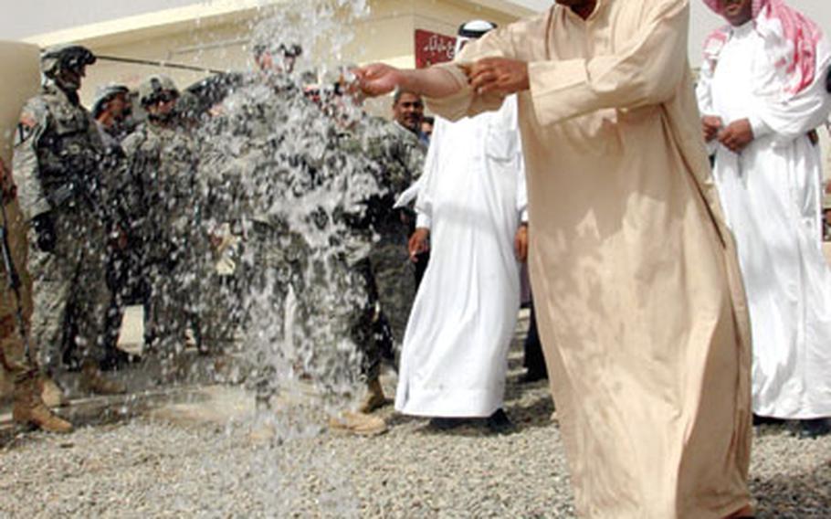 Rasheed Shaker Ali, a resident of the village of Gehawa, washes his hands and takes drinks of water from a new well paid for by the U.S. Army as part of various on-going humanitarian projects.
