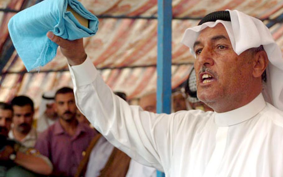 Holding the Quran, a tribal leader from the Khalis area swears to a peace agreement uniting tribes.