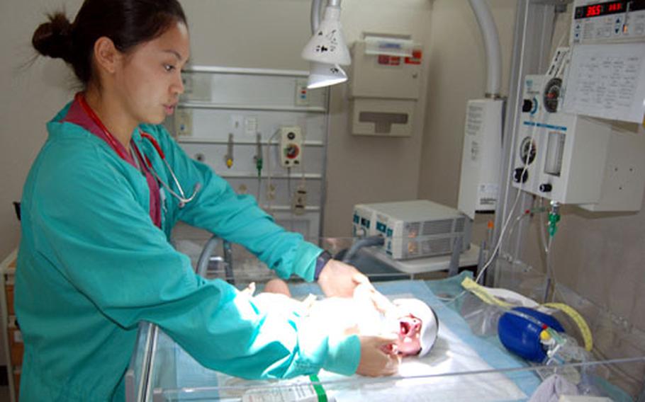 Army 1st Lt. Rachel Frondozo checks on 36-hour-old Ethan William Sisco, who rests under lights while being treated for jaundice Thursday at the 121st Combat Support Hospital’s new Women and Infant Care Unit.