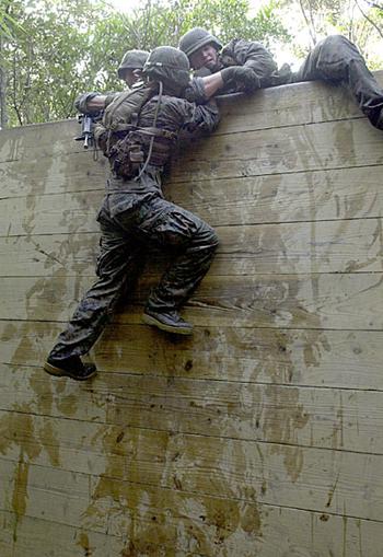 Marines with Marine Air Control Group 18 use teamwork Friday to pull each other over The Wall, one of 31 obstacles on the endurance course. It typically takes a team about six to eight hours to complete the course, although the best time on record was three hours and 45 minutes by a recon team, said Staff Sgt. Brandon Graham, the staff NCO in charge at the center.
