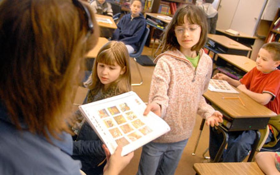 Rachel Nipper, a fifth-grader at Landstuhl Elementary and Middle School, receives her copy of the TerraNova test Wednesday from Jennifer Henry, her homeroom teacher.