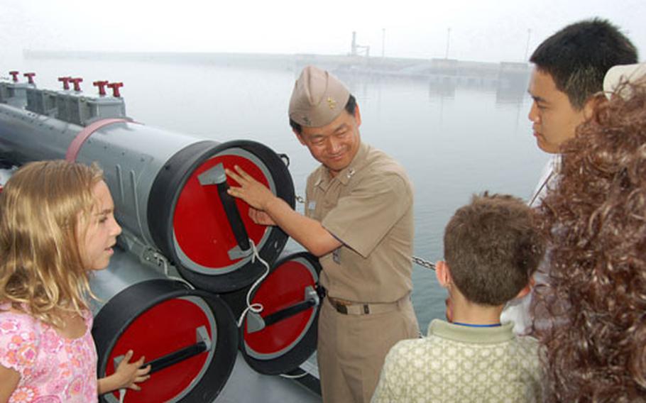 A crewmember aboard ROKS Ulchimoonduk, South Korea’s 2nd Fleet flagship, describes the antisubmarine capabilities of the MK-44 torpedo to sailors and family members from Commander, U.S. Forces Korea. The ship visit was part of a two-day team-building event for U.S. sailors and their family members and their South Korean counterparts.