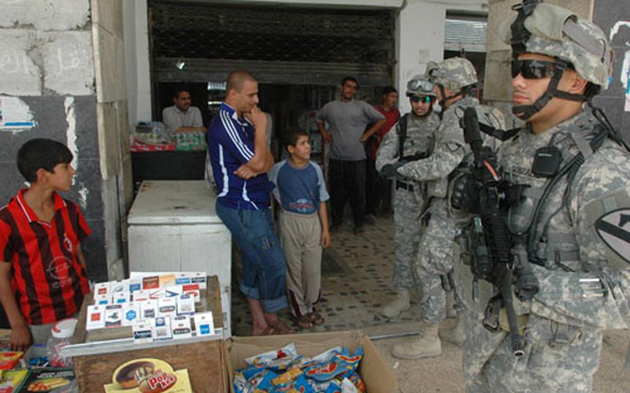 In the foreground at the right is Staff Sgt. Luis Gonzalez, 25, of Queens, N.Y., as he and other troops provide security for high-level diplomats, military leaders and reporters taking a tour of a busy market in downtown Mosul. Gonzalez is a member of the 2nd Battalion, 7th Cavalry Regiment, 4th Brigade, 1st Cavalry Division.