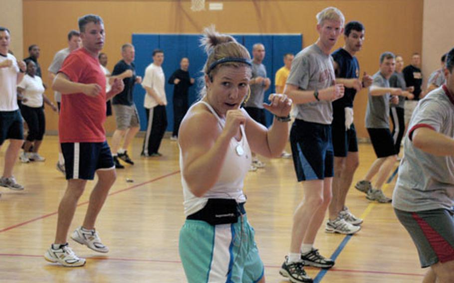 Yokosuka MWR Fitness Director Debbie Deutsch leads the USS Lassen in a kickboxing class July 25. Showing commands that there are more ways to "PT" together other than running is a priority for Deutsch, and Yokosuka offers command classes by request and command swimming three times a week.