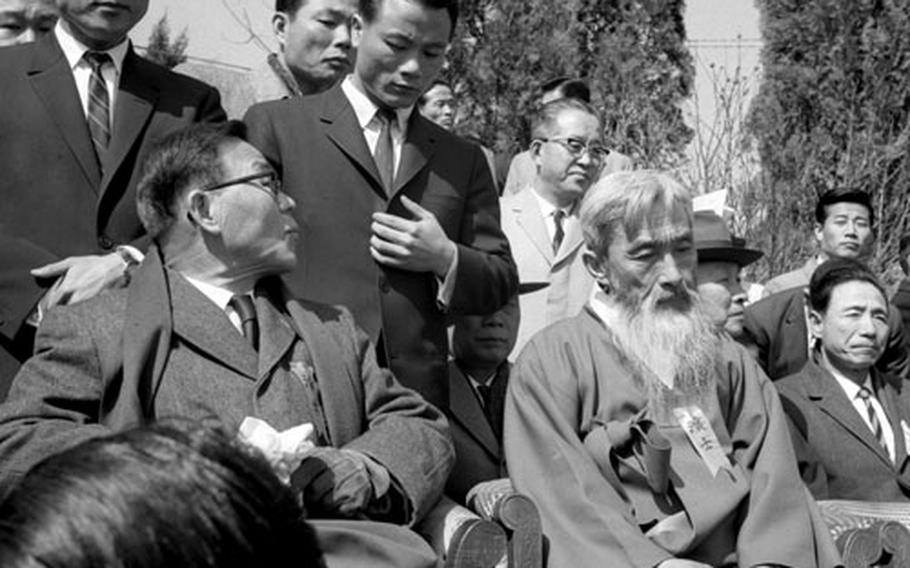 Po Sun Yun and Sok Hon Ham sit onstage during the rally.