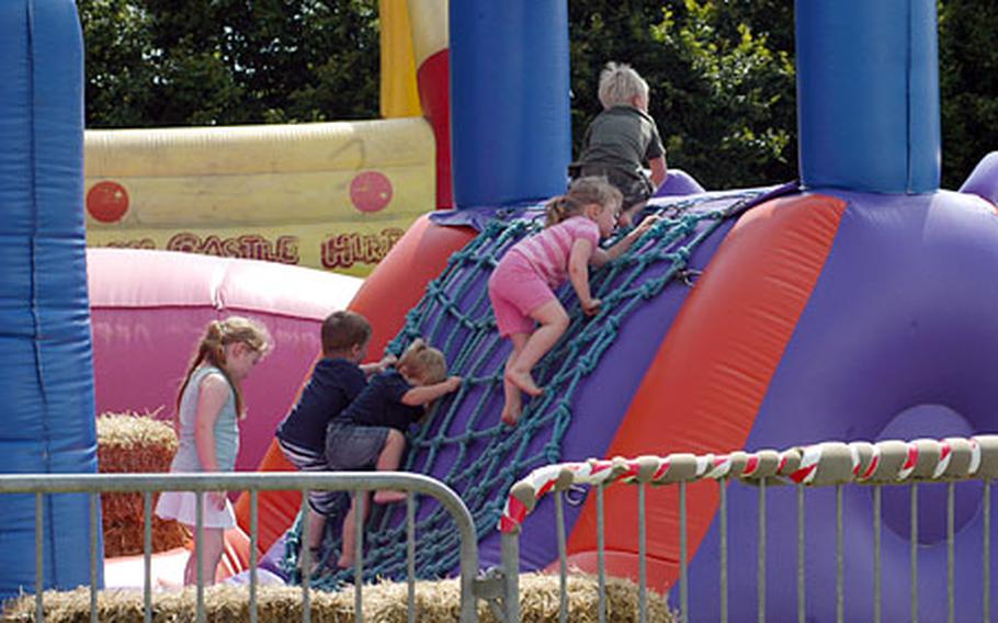 Kids climb up the rope ladder to take a ride down the bouncy castle slide.