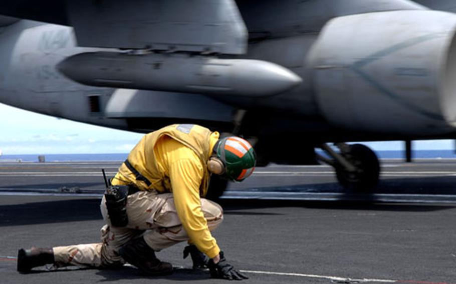 A catapult and arresting gear officer, also known as a shooter, braces himself after directing an S-3B Viking of Sea Control Squadron 31, the Top Cats, to launch off the flight deck of the aircraft carrier USS John C. Stennis during exercise Valiant Shield 2007.