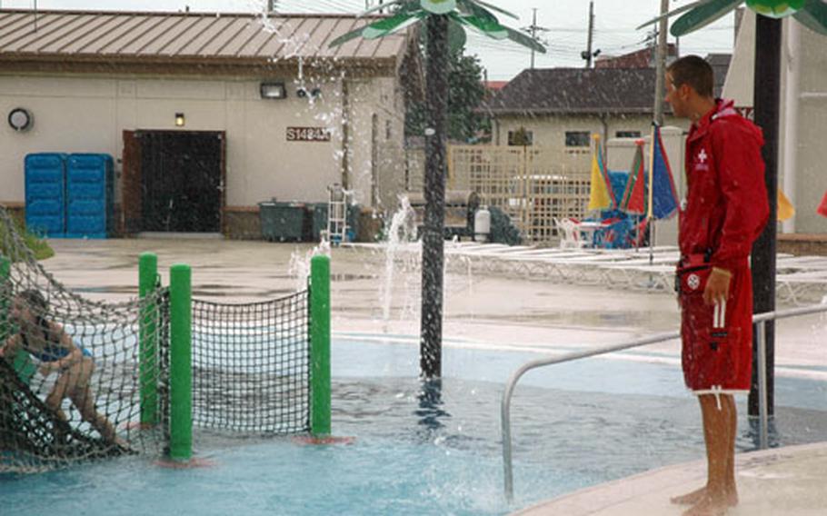Lifeguard Jason Hechtman watches children play at the Splish and Splash water park at Camp Humphreys, South Korea, on Thursday. Hechtman, a lifeguard for two seasons, helped rescue two children from drowning last weekend. Military officials are reviewing the rescue effort and safety rules to avoid future incidents.