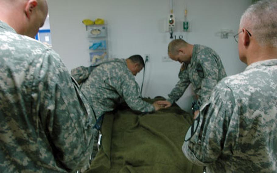Leaders of the 1st Cavalry Division's 3rd Brigade, including Col. David Sutherland, at center right, say a prayer a soldier wounded in combat. The prayer was led by the brigade chaplain, Capt. Jesus Perez, center left.