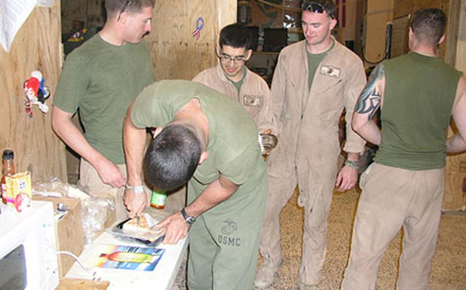 Lance Cpl. Christopher Martinez, 21, of Corpus Christi, Texas, third from left, with fellow-Marines of 3rd Platoon, Company D, 1st Light Armored Reconnaissance Battalion, part of Task Force Highlander, in the cooking area of their patrol base in Rawah, western Anbar province, Iraq.