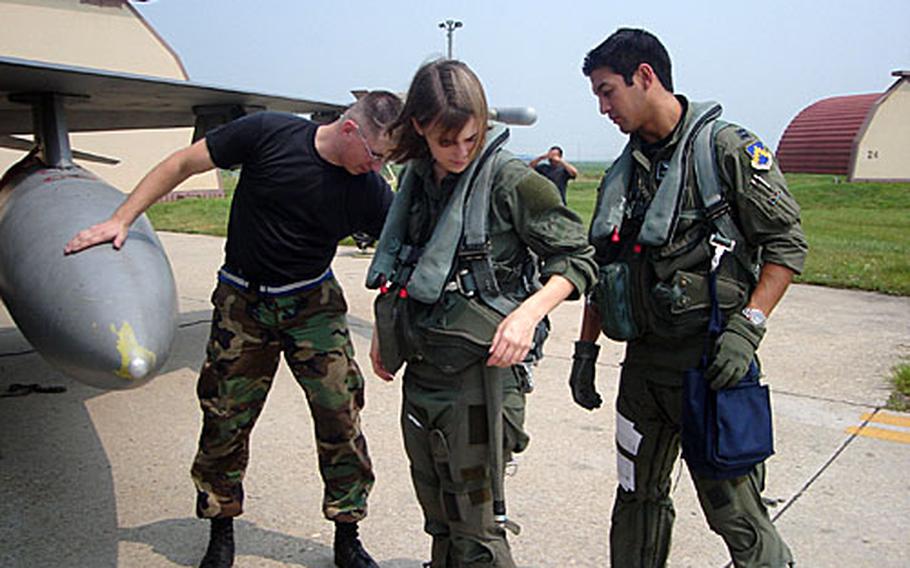 Staff Sgt. Kurt Wurm, left, crew chief, and pilot Capt. Cesar "Toro" Orozco help Stars and Stripes reporter Ashley Rowland prepare for a flight in an F-16 fighter jet at Kunsan Air Base, South Korea.