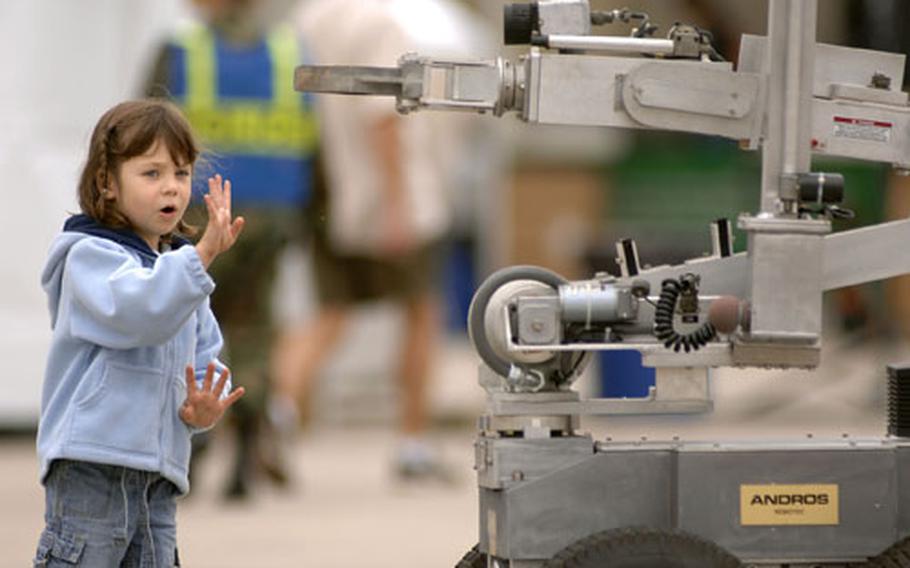 Mia Shunkle, 4, shows an Andros “Rons” robot how old she is. The robot demo, put on by the 435th Civil Engineering Squadron’s explosive ordnance disposal unit, gave spectators a first hand look at how IED’s are handled by the remote controlled machines.