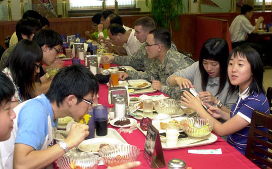 South Korean students have lunch with U.S. soldiers at the Kilbourne Dining Facility on Camp Red Cloud, Friday. Keuktong University sponsored the trip for the high school and college-aged students, who were also scheduled to try out the tactical vehicle simulators at Camp Casey.