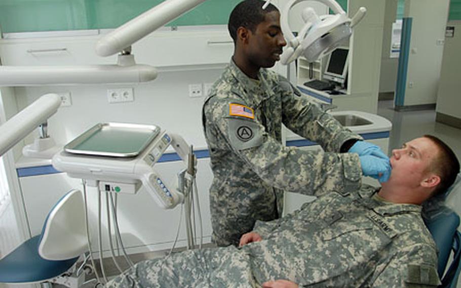 Dental specialists Staff Sgt. Cornelius Summers, 26, of Batesburg-Leesville, S.C., standing, and Pvt. Richard Bradford, 19, of Baltimore, check out some of the state-of-the-art equipment at Grafenwohr's new Health Clinic on Monday.