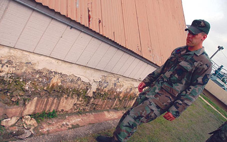 Tech Sgt. Shane Bolles, noncommissioned officer in charge of Kunsan Air Base's water treatment plant, walks past a deteriorating building at the plant, which officials say dates to the Japanese occupation of Korea. "This is probably a perfect example of a building falling apart," he said.