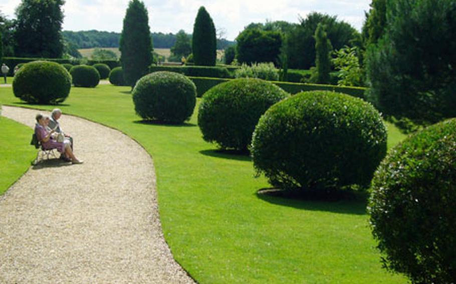 Visitors to the Ickworth estate sit on a bench to soak in the atmosphere of the rear garden. The estate has a unique 18th-century house fitted with a rotunda that towers above numerous acres of woodland and gardens in the quiet countryside.