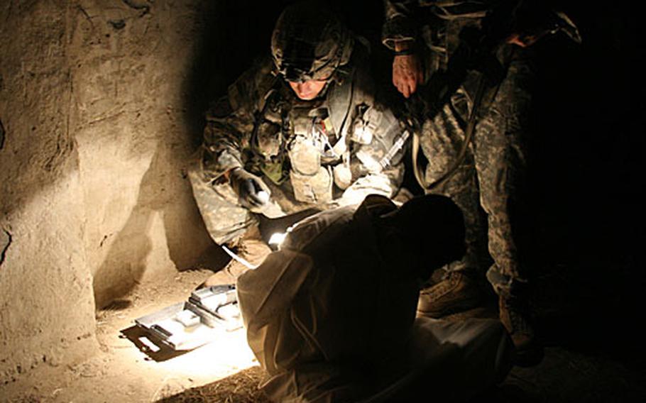 Spc. John Kahn, 26, of Lumberton, N.C. and another soldier test a teenage boy detained in the raid for explosives residue. The boy tested positive along with two other teenagers. They were taken away for further questioning.
