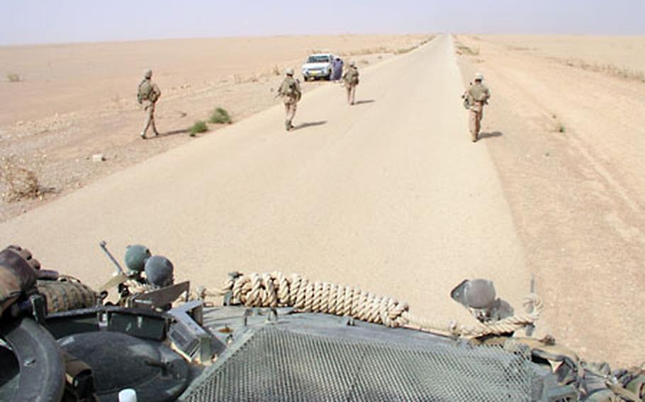 Marines approach a vehicle after flagging it to a stop during a hunt for suspected oil pirates.