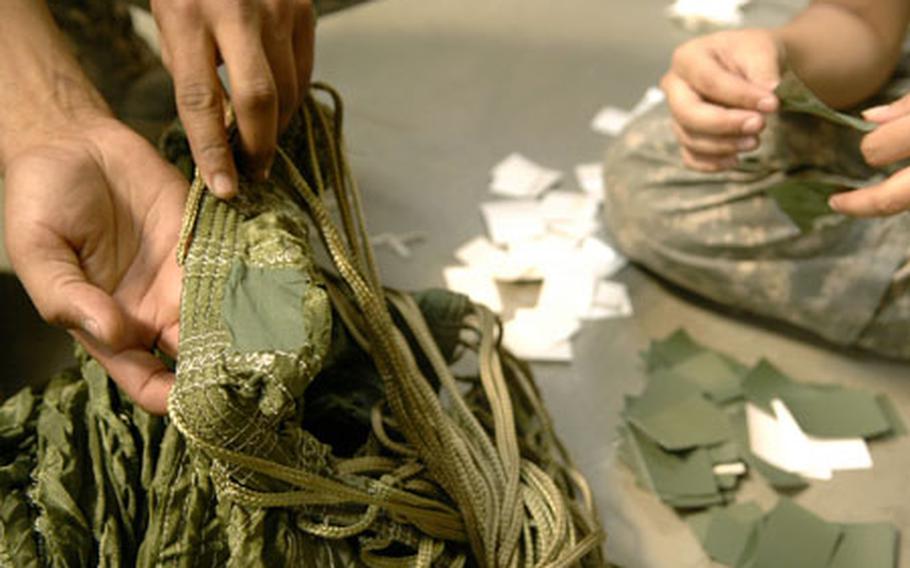 Spc. Dion Gutierrez, an Army National Guard soldier from the 128th Quartermaster Company (Air Drop Light), patches holes made in cargo chutes Tuesday at the Miesau Ammunition Depot, Germany. The Santa Barbara, Calif., guard unit -- TDY for their three-week overseas training -- converted more than 6,200 parachutes originally modified for use in Bosnia in the early 90s.