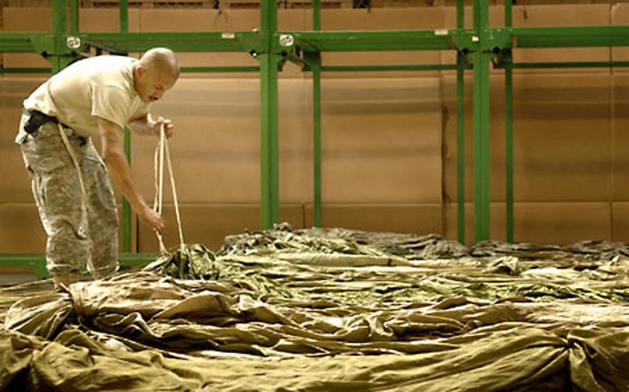 Spc. Dion Gutierrez, an Army National Guard soldier from the 128th Quartermaster Company (Air Drop Light), sorts through cargo chutes Tuesday at the Miesau Ammunition Depot, Germany.
