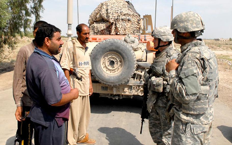 Lt. Col. Kurt Pinkerton talks to several "Volunteers" at their checkpoint in Nasr Wa Salam on Aug. 19. The Volunteers are local residents who have teamed with American forces to provide security in the area. The mostly Sunni civilian watch has had some friction with some of the Shiite Iraqi Army units in the area.
