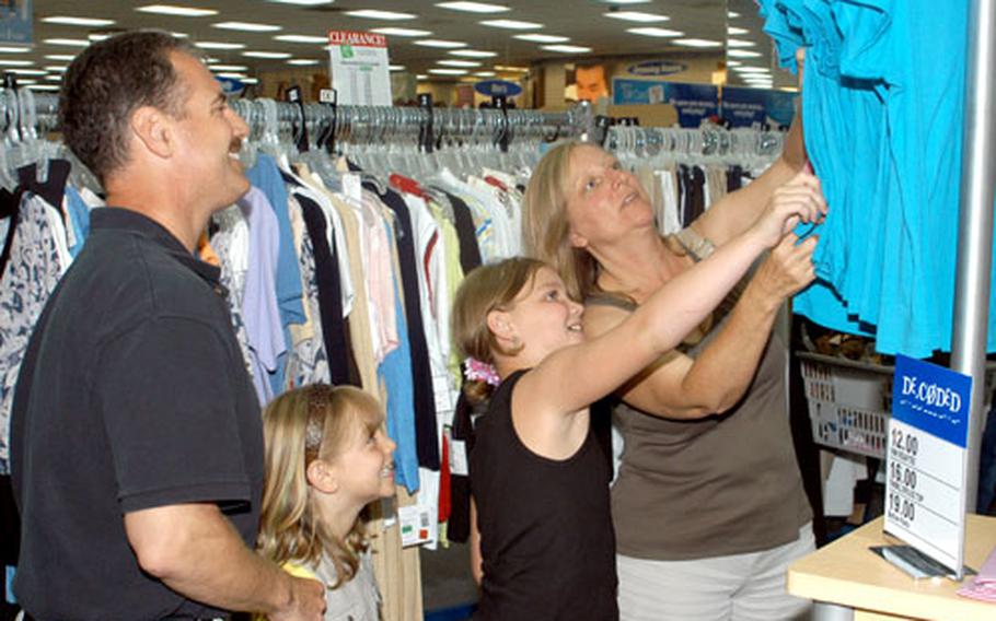 Pamela Caruso, her husband, Navy Capt. Jim Caruso, and their daughters Erica and Amanda shop for clothing Wednesday at the Camp Foster, Okinawa, exchange to replace clothing lost aboard China Airlines Flight CI121. The Carusos were among the 14 Americans on the airplane, which burst into flames Monday shortly after landing at Naha Airport.