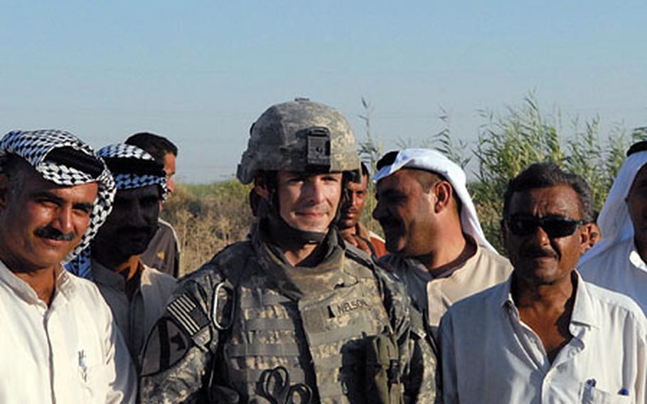 Capt. John Nelson, of the 2nd Battalion, 5th Cavalry Regiment stands between Sheikh Mohsin Ali Kadem al Tamimi (left in the headdress) and Hassan Jabbar Mirhrish on Aug. 23. The two Abu Ghraib residents are among the community members who have partnered together to establish a checkpoint in the Western Baghdad district that will be manned by both Shiites and Sunnis.