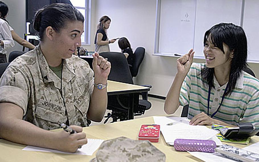 Cpl. Amanda Johnson, 21, from Temeculah, Calif, and Ayami Uechi, 16, a student from Uruma City, agree that the word in question, skoshi, means "a little" during the week long Camp Courtney Summer English Class.