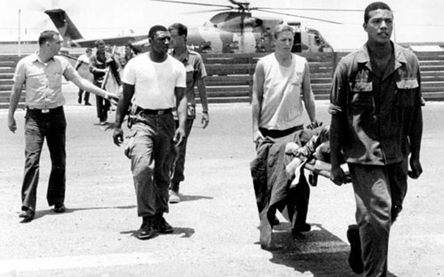 Hospital corpsmen carry wounded servicemembers from a helicopter at the Naval Support Activity Hospital, Da Nang, in 1968.