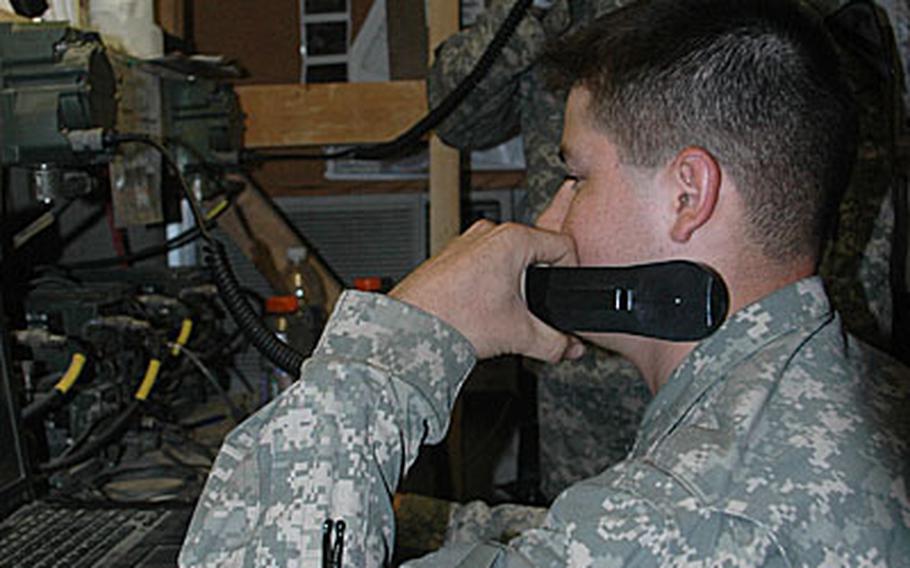 At the platoon's Paladin howitzer fire center, Pfc. Fernely Villatoro, 20, of Bakersfield, Calif., foreground, and Spc. Daniel Villareal, 25, a native of Asherton, Texas, communicate with the gun's operators, who are at another location.