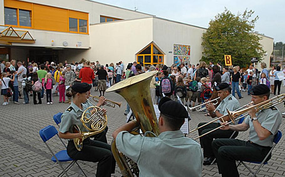Members of the USAREUR band play a tune as students, teachers and parents gather before the first day of school at Darmstadt, Germany. It is the first year of a combined middle and elementary school in Darmstadt, but probably the school's final year as the community is scheduled to close.
