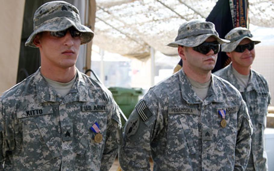 Sgt. Christofer M. Kitto, 23, of Altamont, N.Y., and Sgt. Michael C. Pesamoska, 25, of Lake Orion, Mich., stand at parade rest after receiving the Soldier's Medal from Lt. Gen. Raymond C. Ordierno during a ceremony Wednesday at Combat Outpost Cleary, south of Baghdad. The two sergeants received the medal, the Army's highest non-combat award, after saving the lives of three soldiers after their Humvee flipped over into a water-filled canal during a night patrol in April 2007.