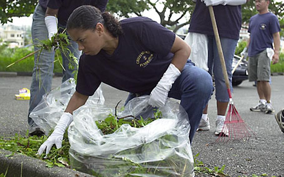 Chief Petty Officer (sel.) Edith LaFrazier, 36, from San Pablo, Calif., with Marine Wing Headquarters Squadron 1, bags leaves and grass at the Okinawa Children's Zoo in Okinawa City on Sunday. About 36 chief petty officer selectees were at the zoo cleaning up as part of a community-service project.