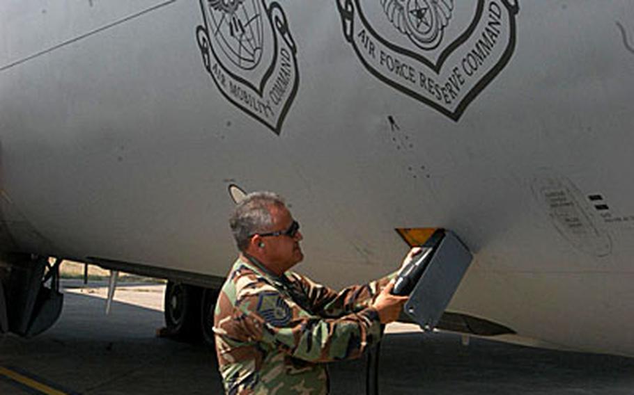 Master Sgt. Ric Ballinas disconnects an electric supply line from a KC-135 Stratotanker parked on the runway at Incirlik Air Base in Turkey. The planes routinely take to the air to refuel U.S. cargo planes over the Black Sea.