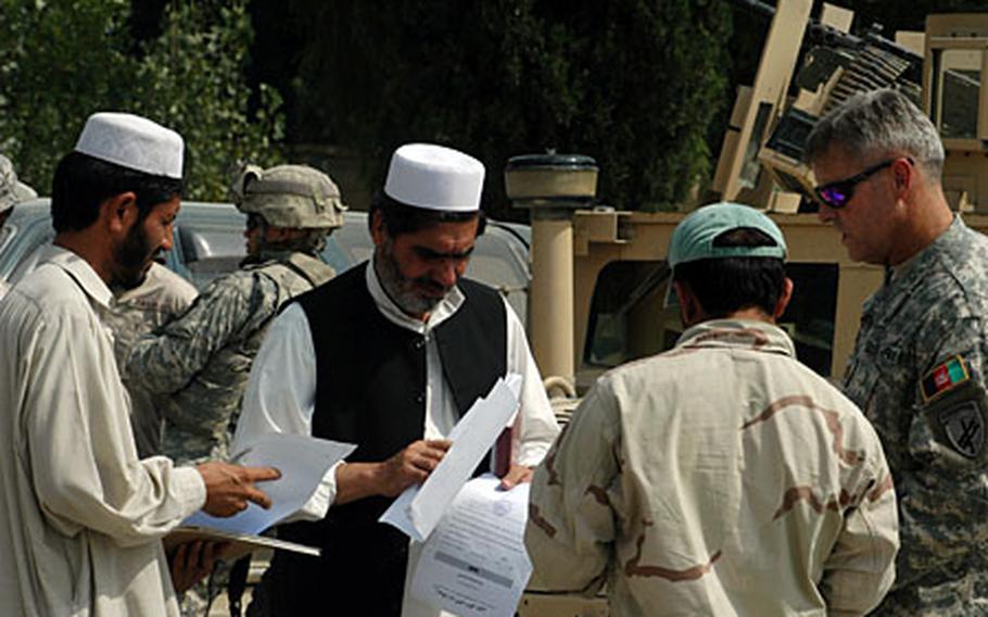Maj. Steven Kieler, right, greets participants of a recent Khost province emergency management meeting.