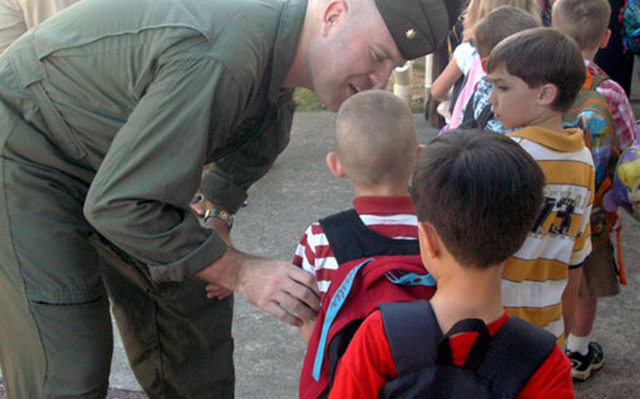 Major T.B. "Sweaty" Missler whispers words of encouragement to his son Logan, 5, on his first day of kindergarten at Killin Elementary School. Logan was one of about 800 students attending their first day of kindergarten Wednesday on Okinawa.