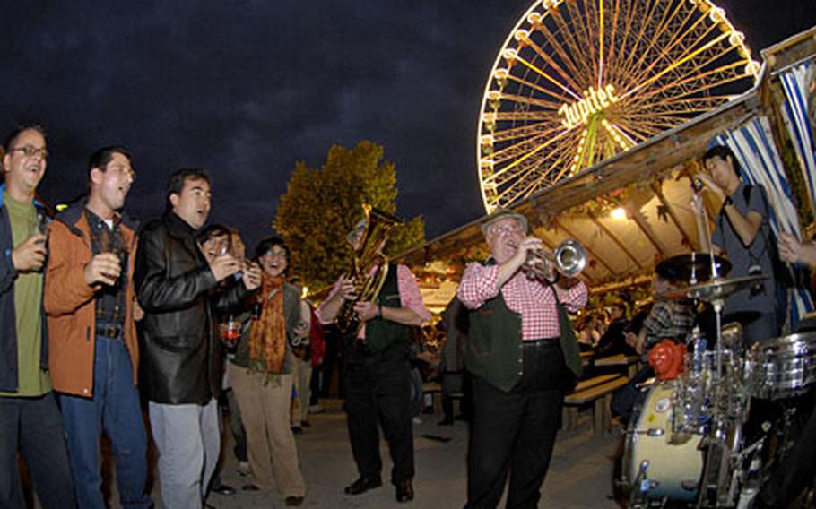 Participants in Bad Dürkheim’s Wurstmarkt (Sausage Market) festival sway and sing with a traditional German oompah band Friday during opening night. The heart of the festival can be found in the “Schubkärchler” or wheel barrel area where all the local wine makers have tents set up for drinking.