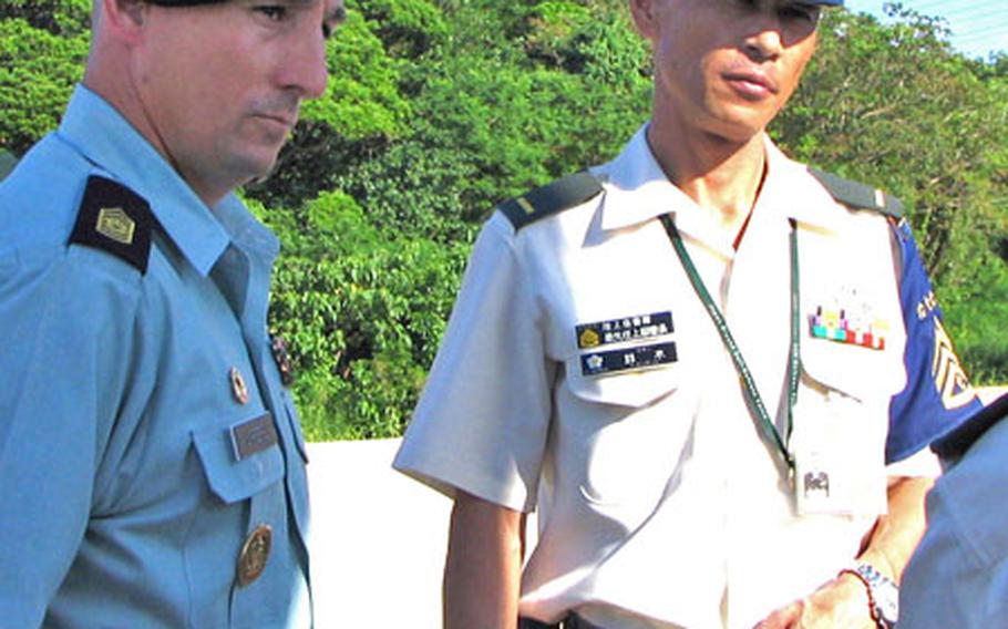 Army Command Sgt. Maj. Michael D. Kuppers, of the 1st Battalion, 1st Air Defense Artillery Regiment, and Command Sgt. Maj. Hiroo Suzuki, sergeant major of the Japan Ground Self-Defense Force, get a briefing on the PAC-3 missile battery Friday on Kadena Air Base.